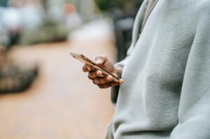 closeup of a woman scrolling social media on her phone, taken outside